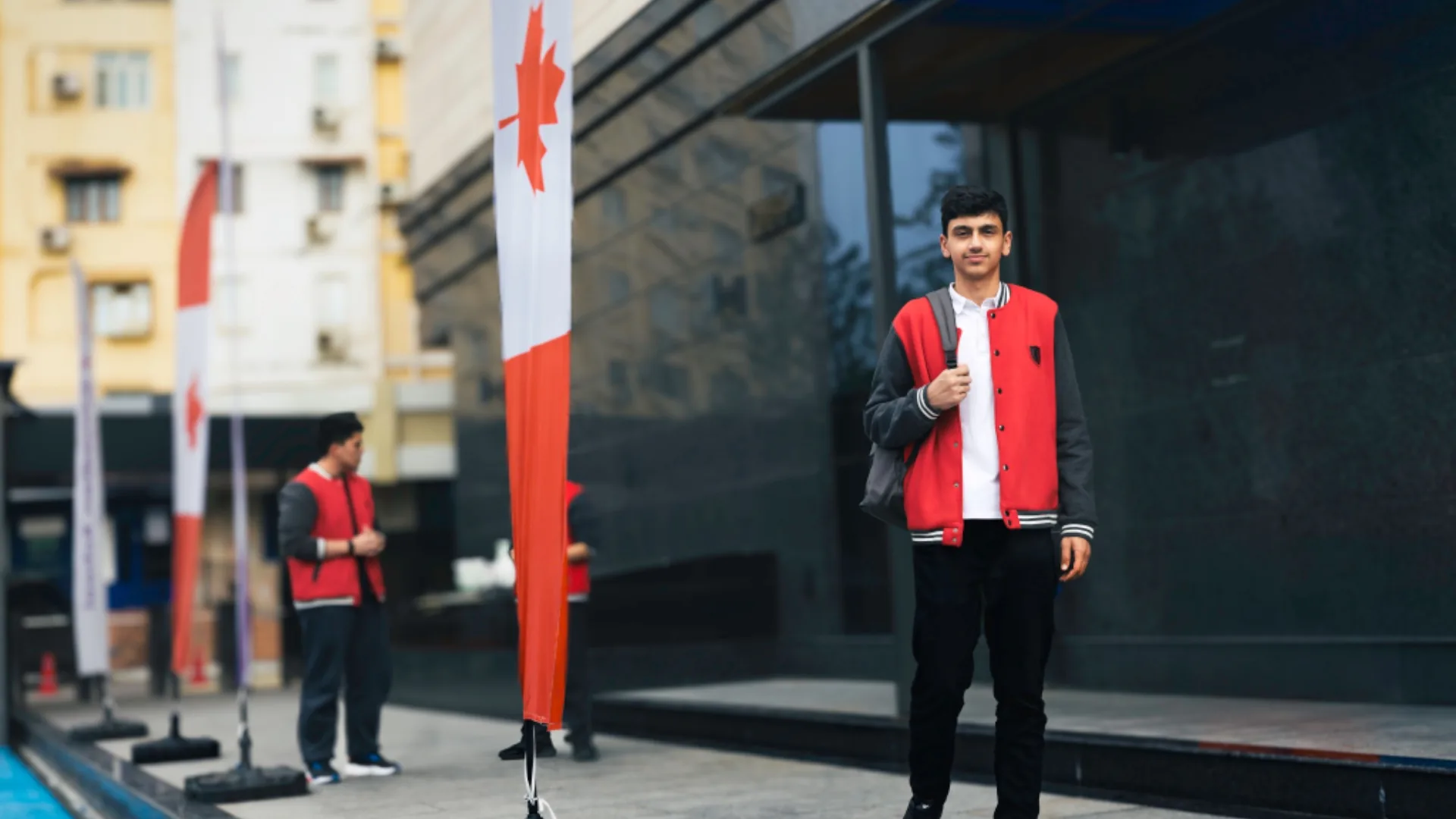 A CST high school student in front of the Canadian flag